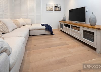 Oak flooring used in living area with tv and sofa
