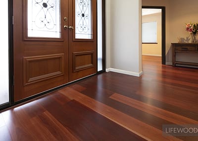 Jarrah floorboards with white skirting boards cut around door entrance